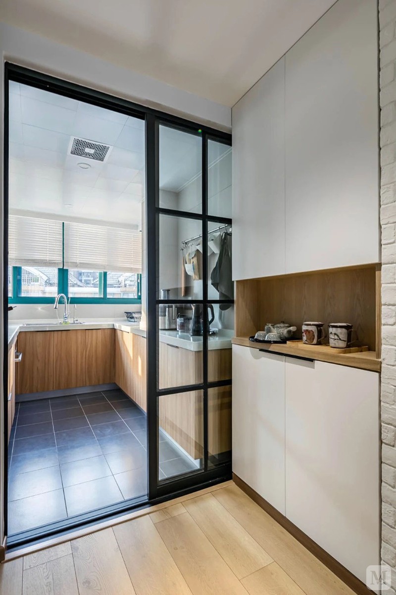 厨房门外的餐边柜中空的设计,白色与木色的柜体,与黑框玻璃推门搭配