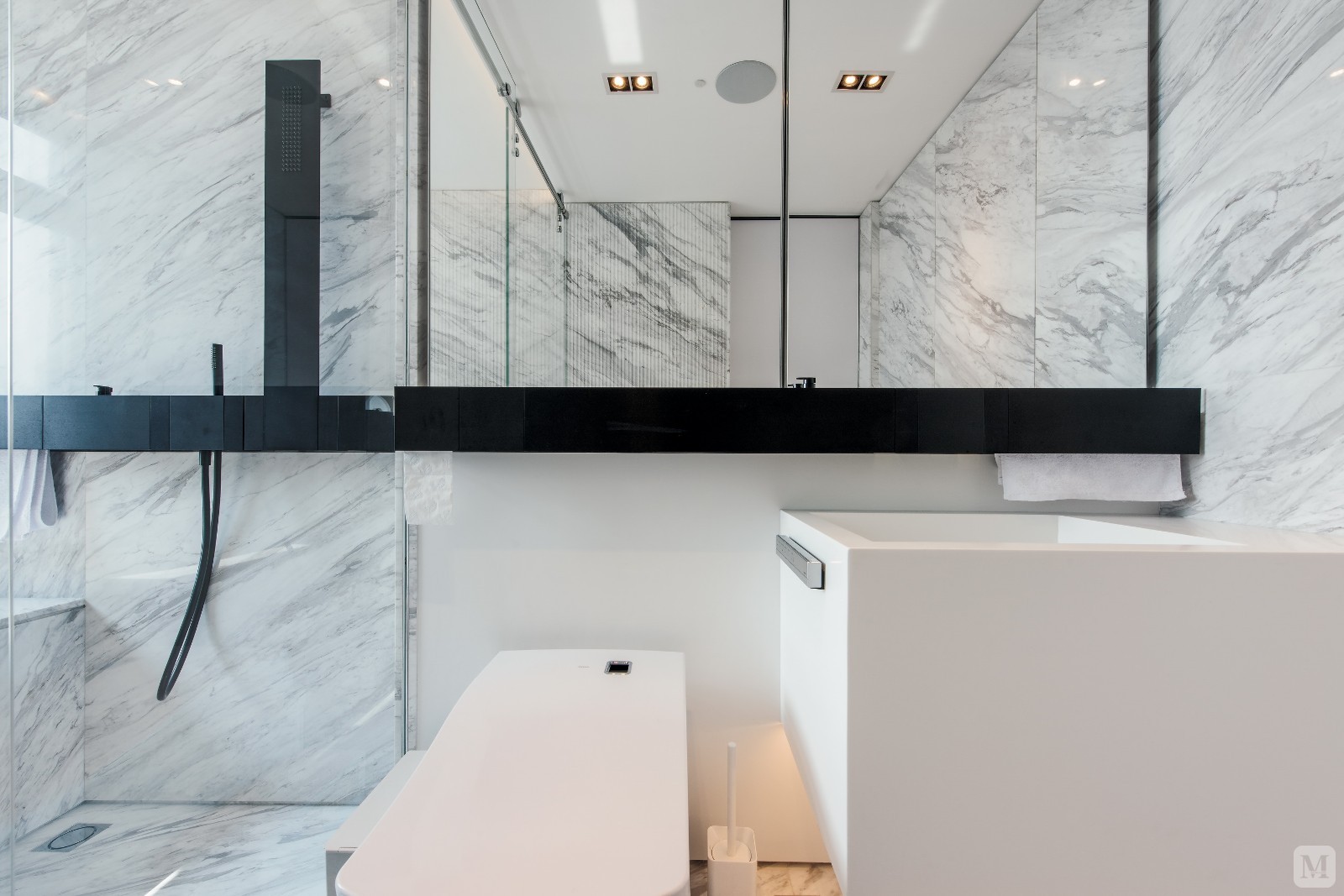 大理石材质墙壁，配上瓷白卫浴在暖色系的灯光下打造出舒适的沐浴环境