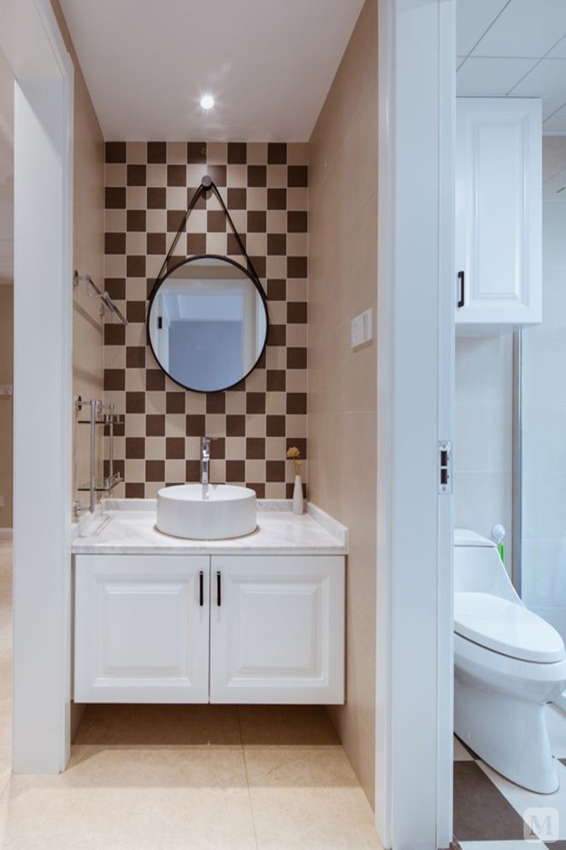 卫生间把洗手盆设在门外,以白 褐交替错开的墙面砖张贴,台上盆 圆镜的