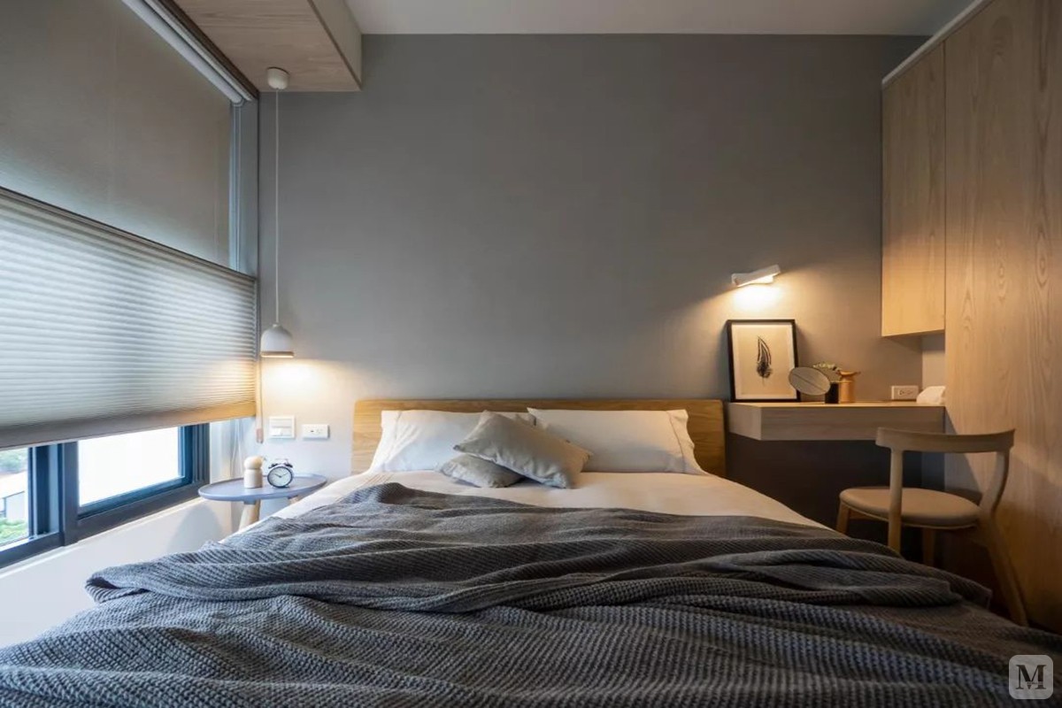 卧室同样以简约与木质感的空间为主，白+灰色的床单搭配，简单轻松的空间，令人睡意满满。
