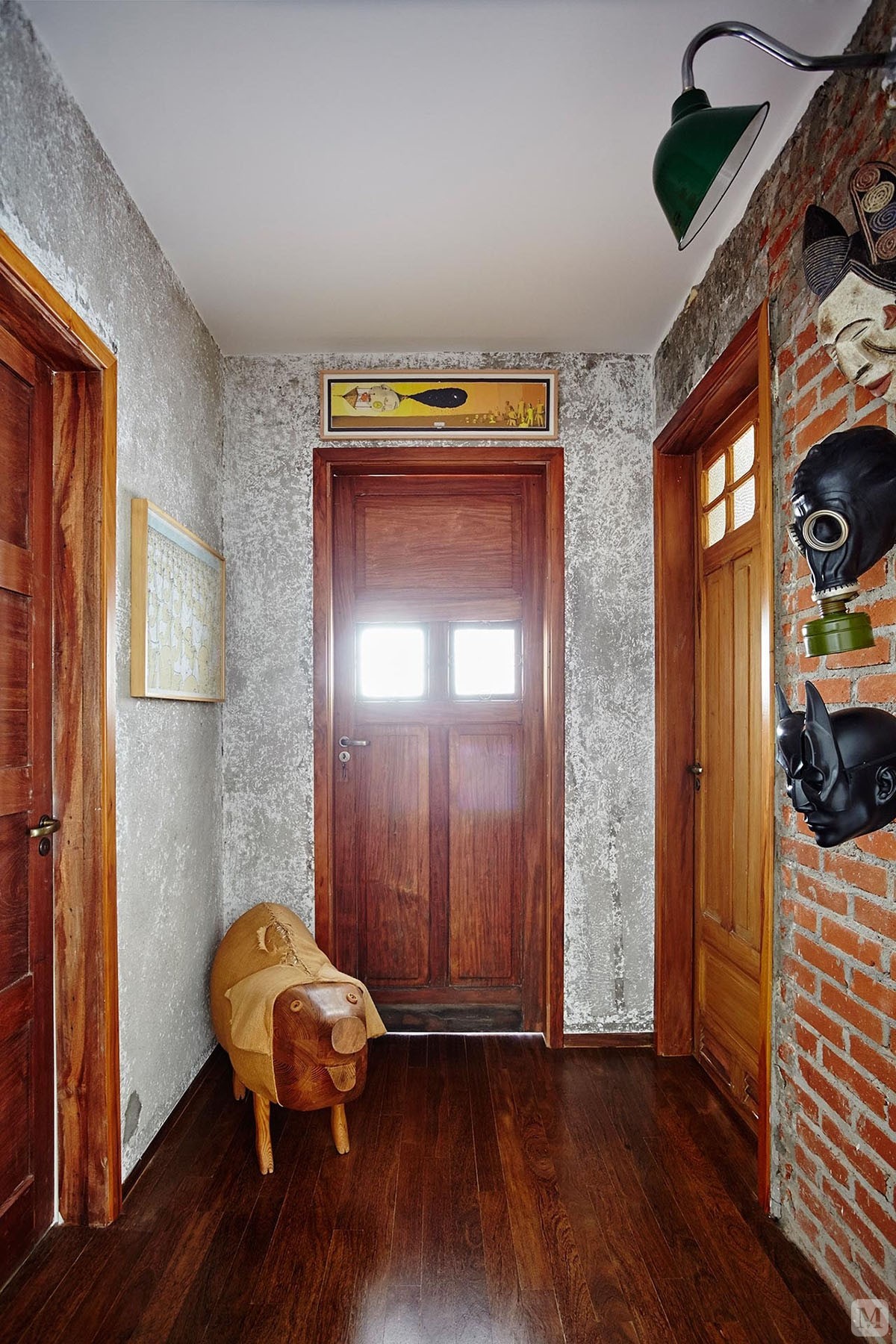 深色的木质地板和几扇门相互呼应，原始的文化砖可见独特的设计。

入户门厅的设计是独特而具有后现代风格，也可一眼看见客厅的空间。